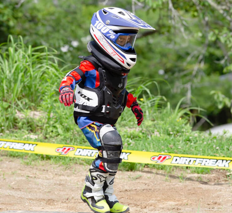 子供がバイクの装備をした状態で走っている様子